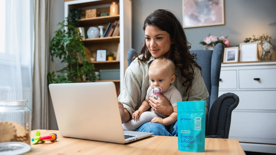 busy mom working at the laptop with her baby on her lap and a Neuro Energy and Focus package on the table