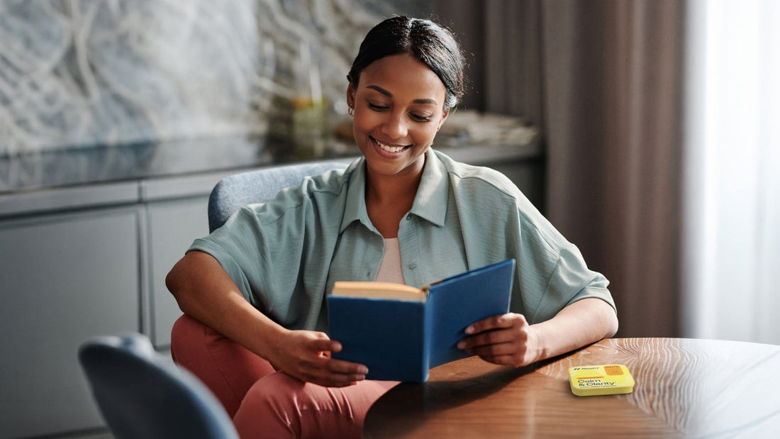 calm woman smiling while reading with a Neuro Calm and Clarity mints package next to her